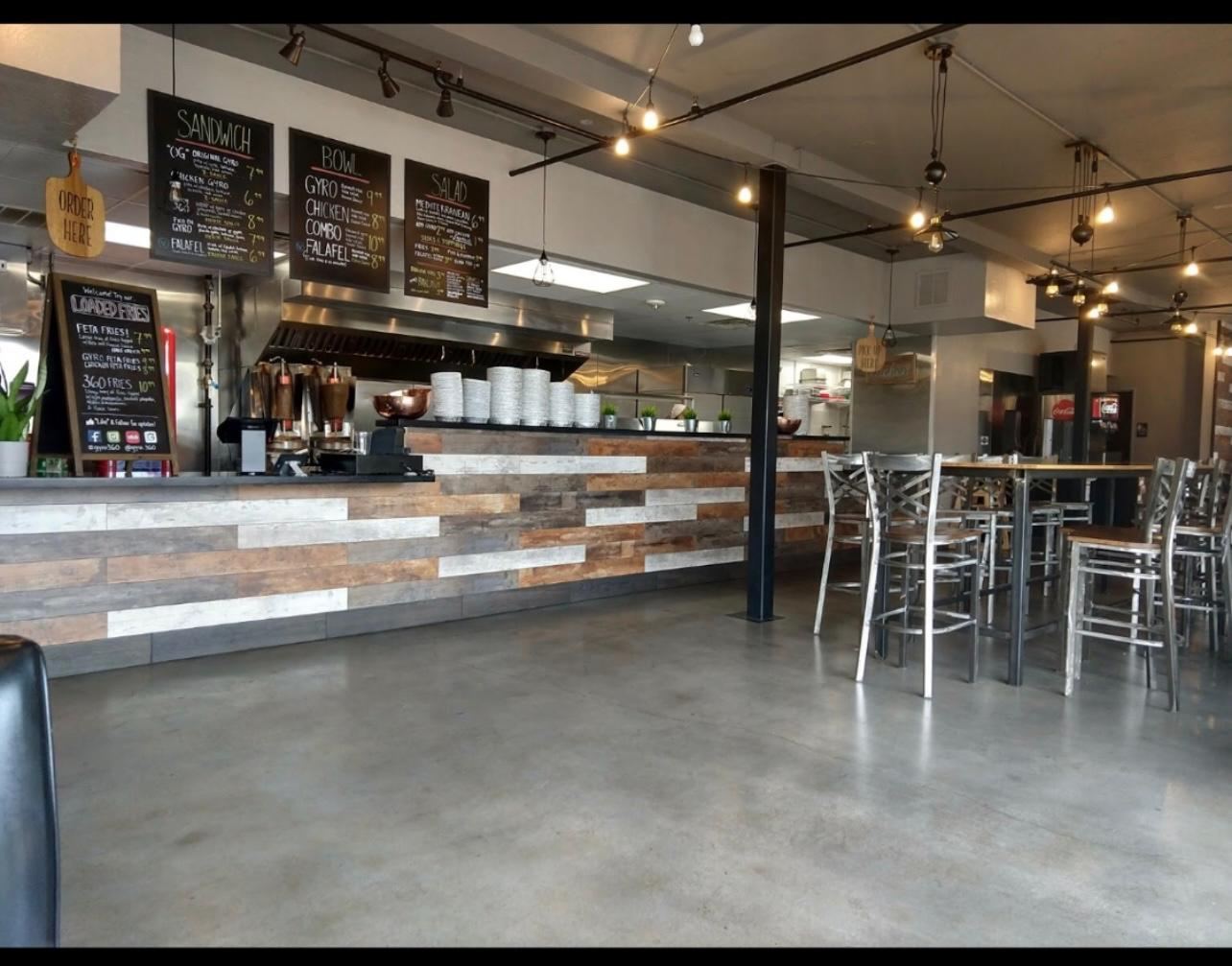 Finished cafe counter with chalkboard menu boards, polished concrete floor and track lighting
