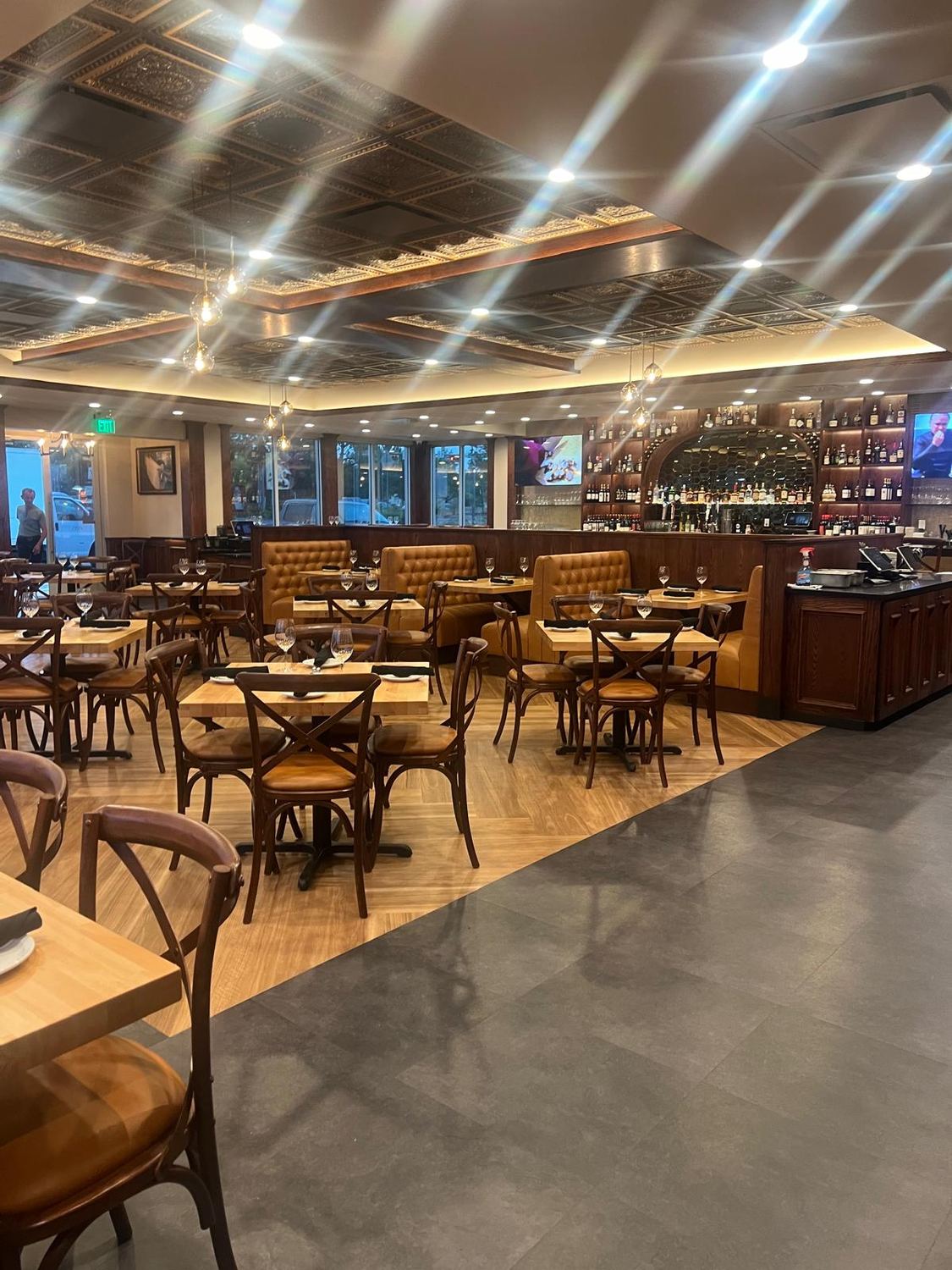 Finished restaurant dining room with pressed tin ceiling, bentwood chairs and a bar along the back wall